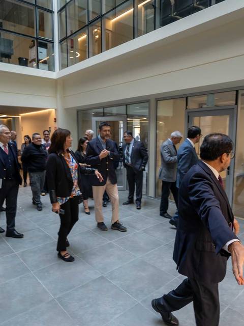 Un grupo de personas sigue a un líder en un moderno espacio de oficina.