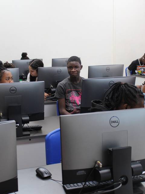 Una sala de computación llena de estudiantes concentrados en sus pantallas.