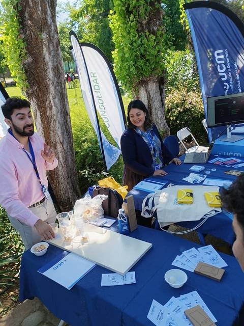 Un par de personas en un stand promocionando productos y servicios al aire libre.