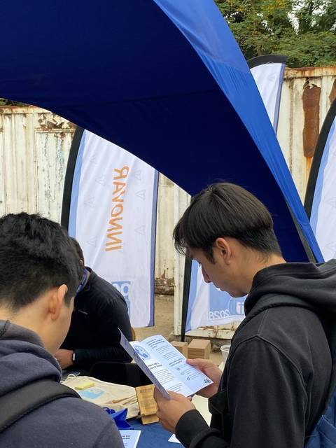 Estudiantes informándose en un stand de la UCM sobre oportunidades de desarrollo universitario.
