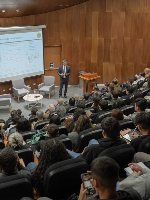 Una charla educativa con una gran audiencia en una sala moderna.