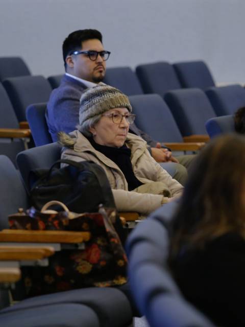 Un grupo de personas sentadas en una sala durante una charla.