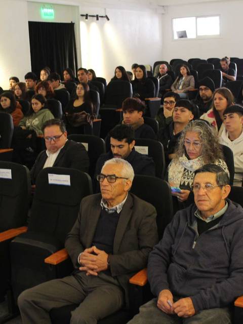 Un grupo de personas sentadas en un auditorio durante una presentación.