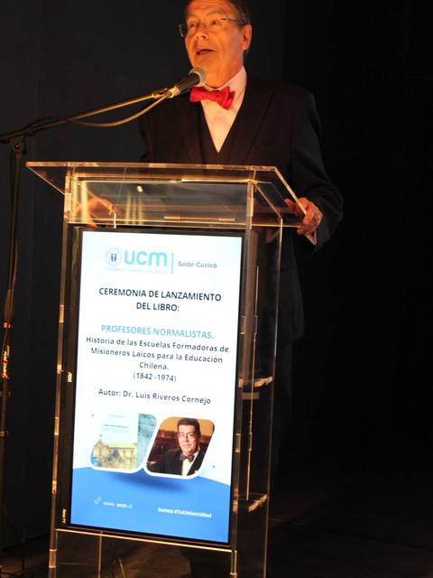 Un hombre habla en una ceremonia de lanzamiento de un libro sobre educación en Chile.