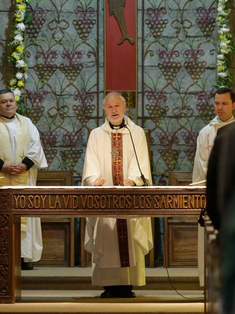 Una ceremonia religiosa en una iglesia con un sacerdote frente a la congregación.