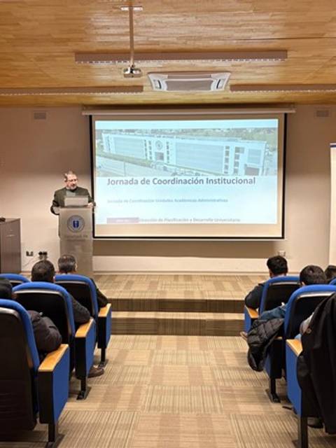 Una reunión de coordinación institucional con varias personas escuchando al expositor.