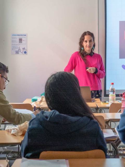 Una profesora está dando una charla interactiva a sus alumnos en un aula.