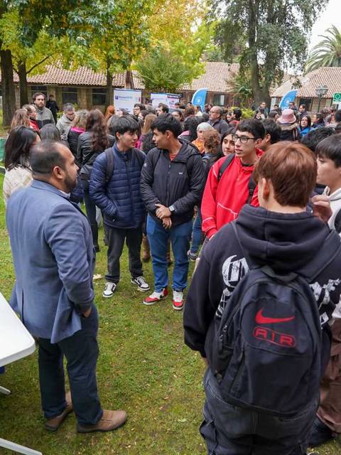 Un grupo de estudiantes conversa animadamente en la zona de networking de un evento educativo.