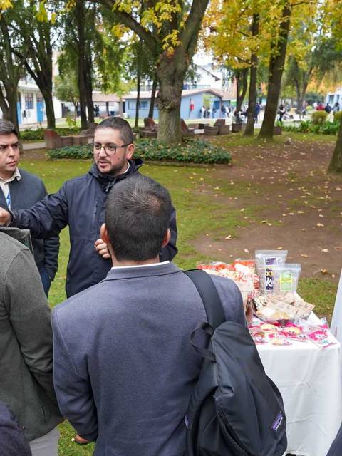 Un grupo de personas conversando en un evento al aire libre en la región del Maule.