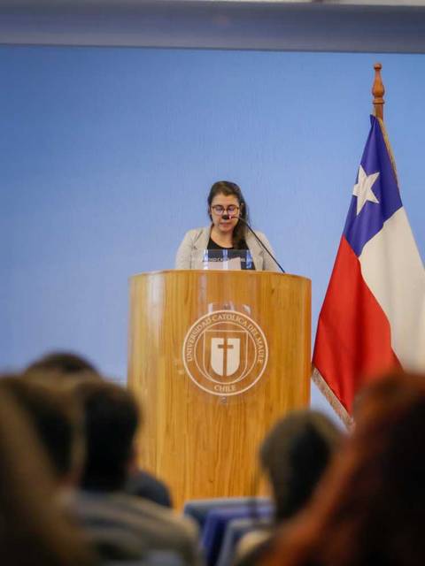 Una mujer da un discurso en un evento académico en Chile.