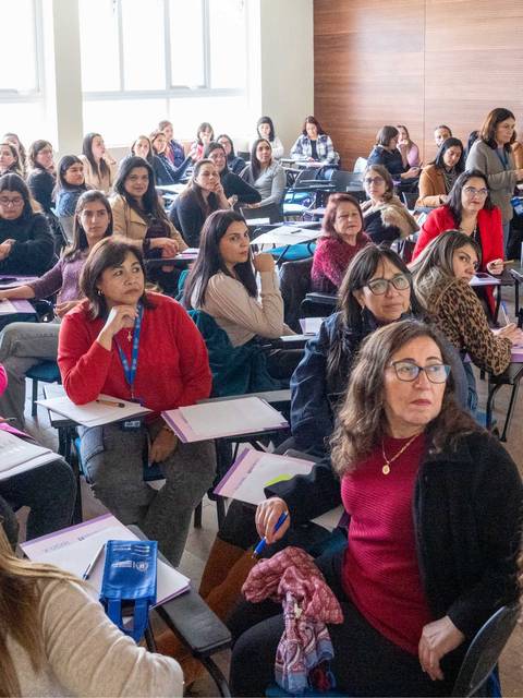 Un grupo numeroso de mujeres participando en una charla o clase.
