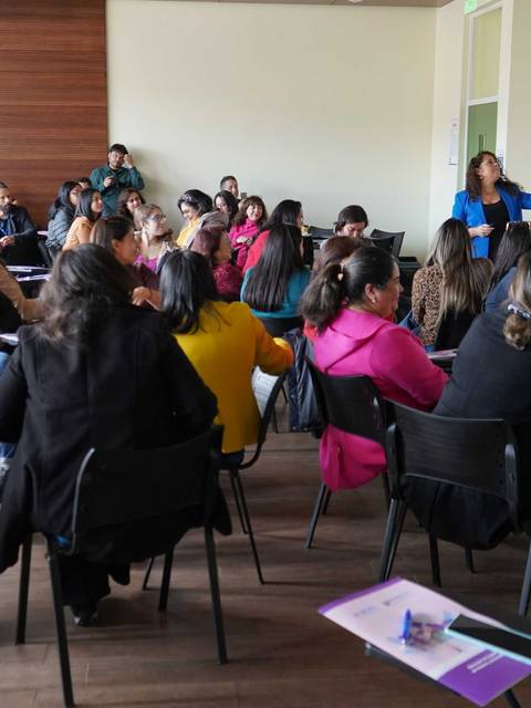 Una sala llena de mujeres participando activamente en una charla o taller.