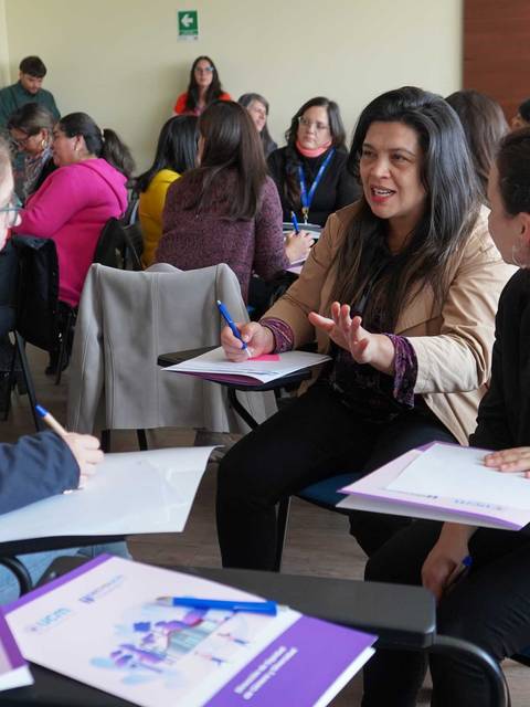 Un grupo de mujeres participando activamente en una charla en un espacio de trabajo.