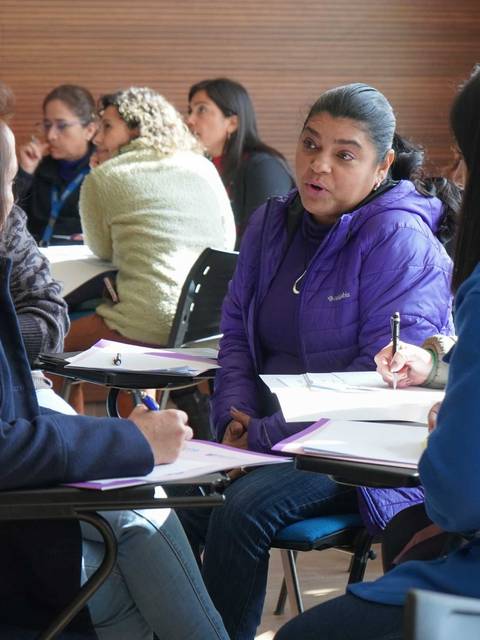 Un grupo de mujeres conversando y trabajando en un ambiente de aprendizaje colaborativo.