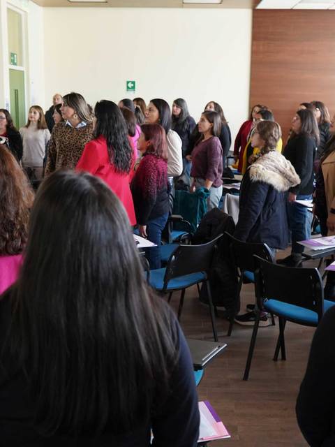 Un grupo de mujeres en un taller escuchando atentamente a la expositora.