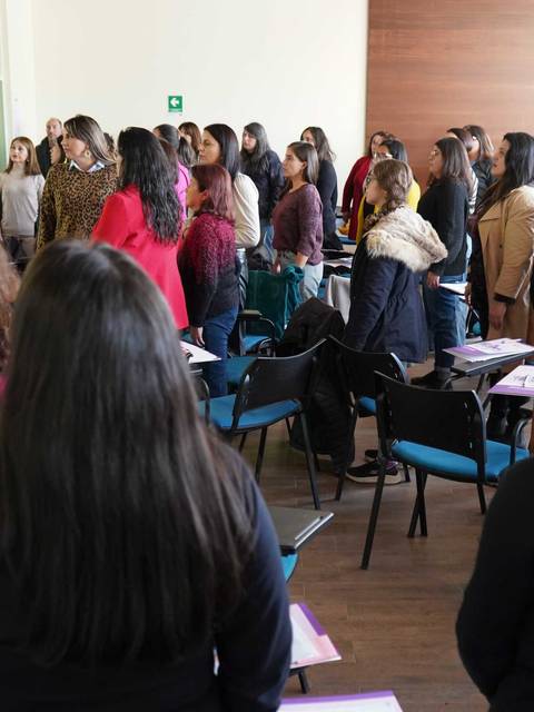 Un grupo de mujeres participando activamente en una charla en un salón de clases.