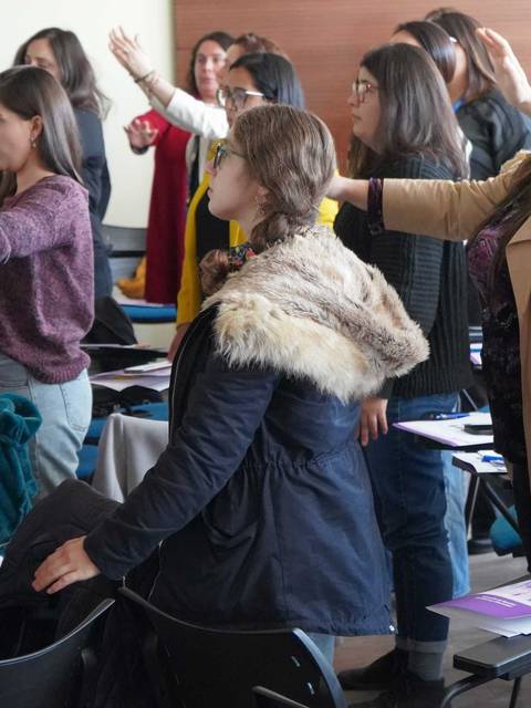 Un grupo de mujeres participando en una actividad de empoderamiento en una sala.