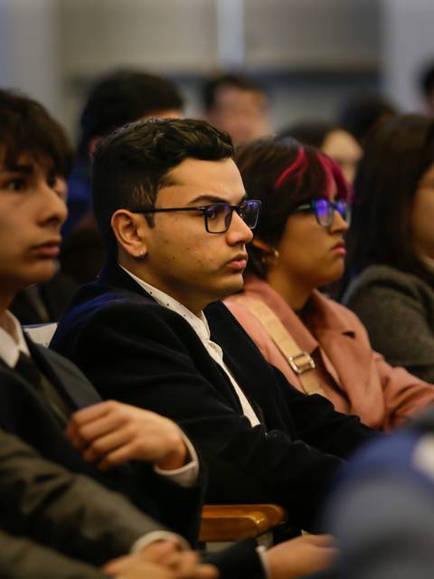 Un grupo de jóvenes escucha atentamente durante una charla.