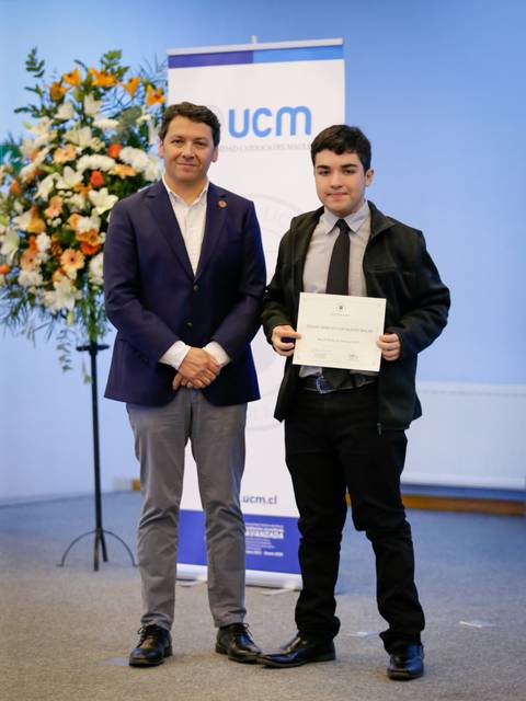 Un joven recibe un reconocimiento en una ceremonia formal.