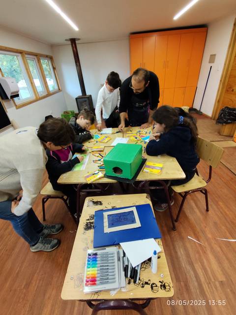 Un grupo de personas trabaja en manualidades en una mesa en un ambiente acogedor.