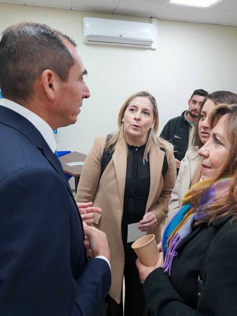 Un grupo de personas conversando en un evento en un ambiente profesional.