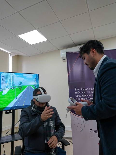 Una persona usando gafas de realidad virtual mientras recibe instrucciones en un entorno moderno.