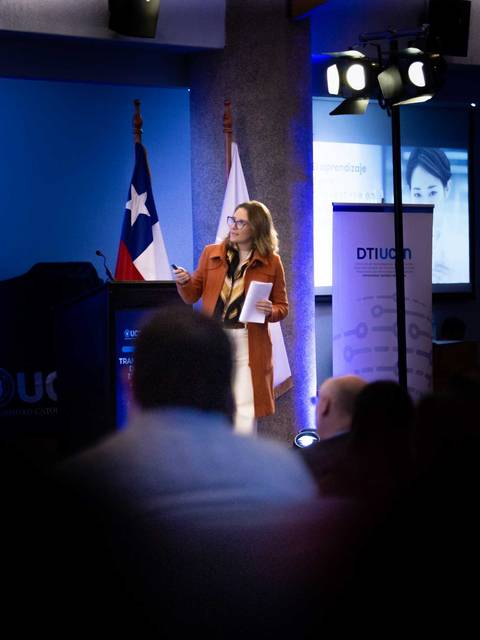 Una presentadora habla frente a un público en un evento en Chile.