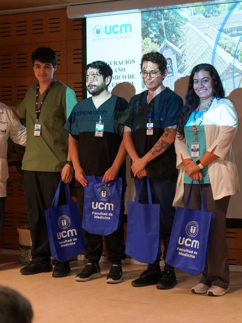 Un grupo de estudiantes y un profesor posan juntos con bolsas en un evento en Talca.