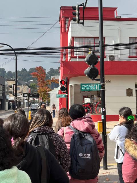 Un grupo de personas esperando para cruzar la calle en una zona urbana.