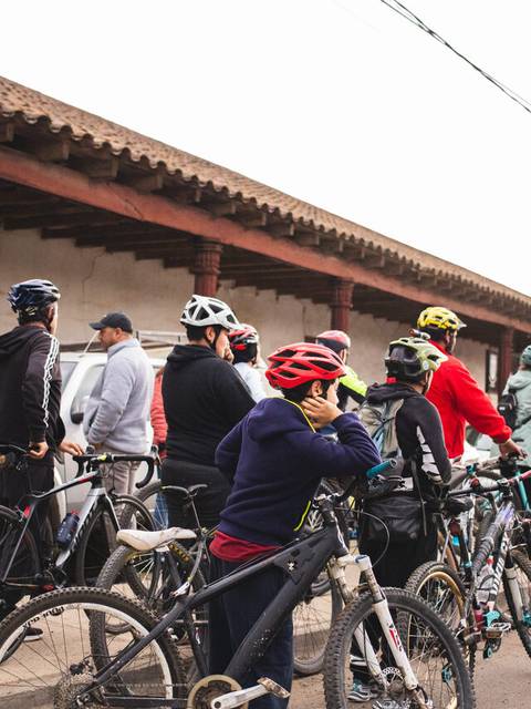 Un grupo de ciclistas se prepara para una salida en un entorno rural.
