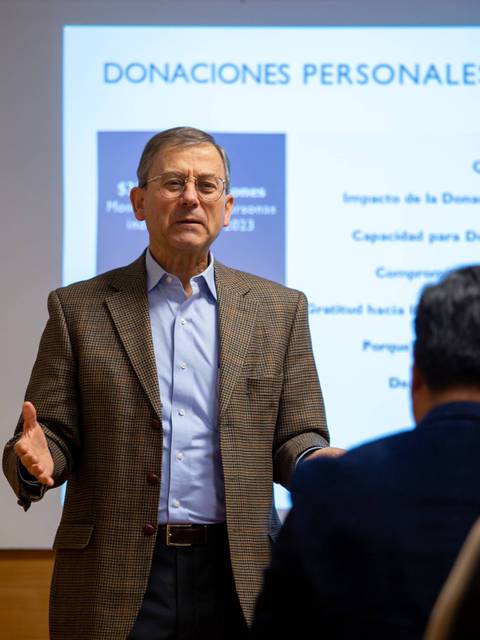 Un hombre exponiendo sobre donaciones personales en una charla.