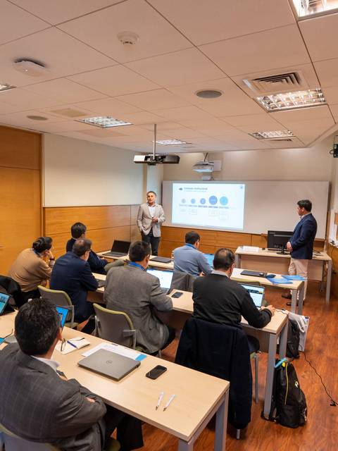 Una clase en un ambiente académico donde se presenta un tema en un proyector.