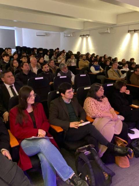 Una gran cantidad de personas sentadas en un auditorio durante una presentación.