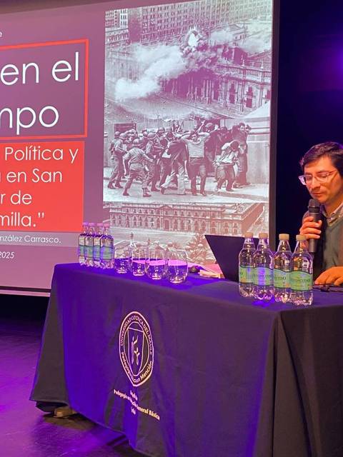 Un profesor presenta la charla sobre violencia política en un escenario académico.