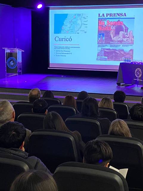 Una charla en un auditorio sobre Curicó donde se presenta información y un mapa de la localidad.