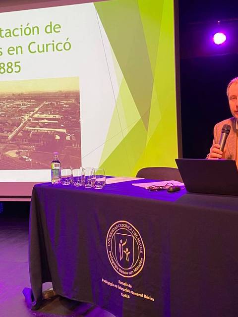 Un expositor presenta sobre las leyes laicas en Curicó frente a una audiencia.