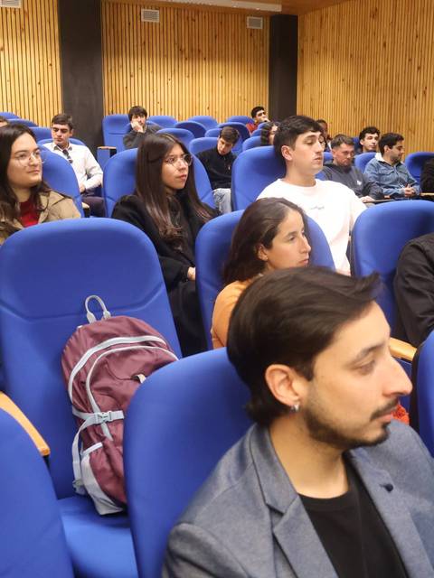 Un grupo de estudiantes escuchando atentamente en un auditorio.