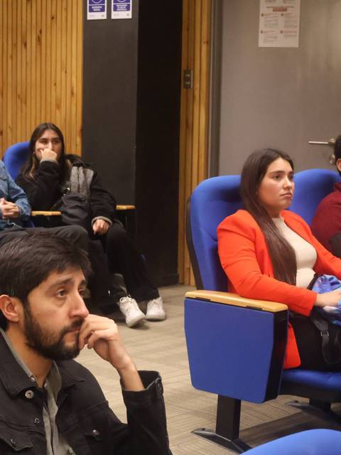 Un grupo de estudiantes participan en una charla en un auditorio.