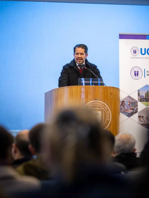 Un hombre está hablando desde un podio en un evento académico.
