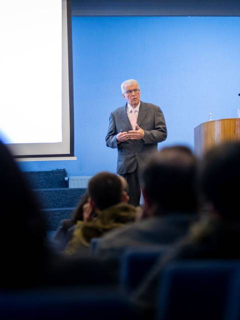 Un expositor presenta una conferencia sobre la sanidad del cuerpo y del alma en un auditorio lleno de público.