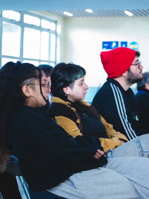 Un grupo de personas sentadas escuchando atentamente en un evento.