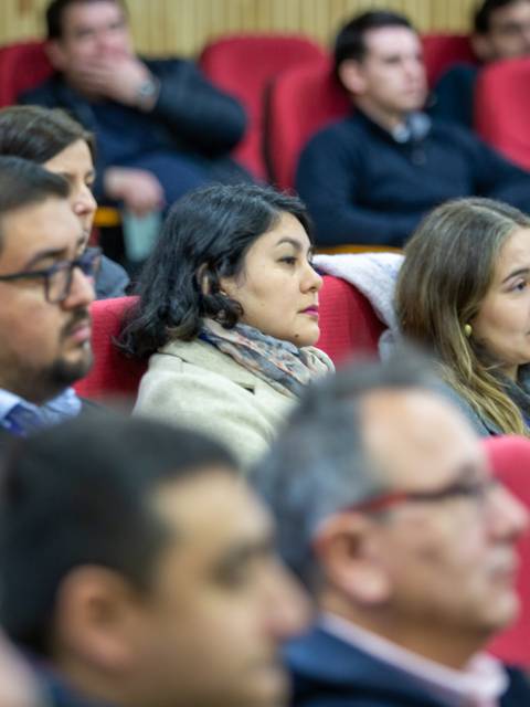 Un grupo de personas escuchando atentamente en un auditorio.