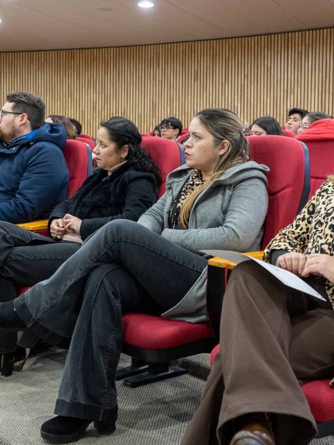 Un grupo de personas escuchando atentamente en una sala de conferencias.