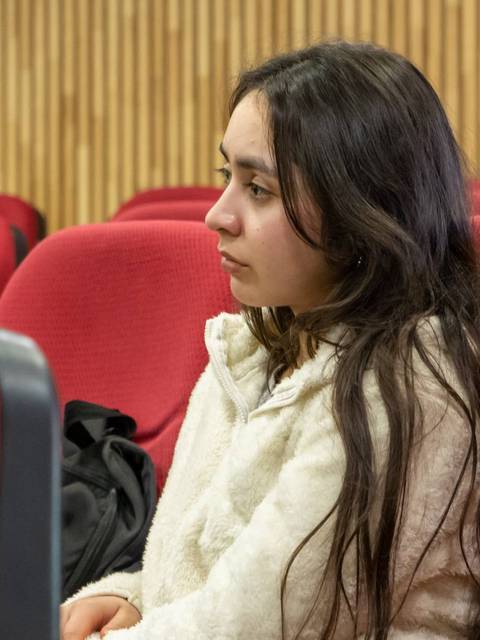 Un grupo de jóvenes escucha atentamente en una sala de clases.