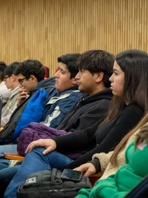 Un grupo de jóvenes atentos escuchando una charla en un auditorio.