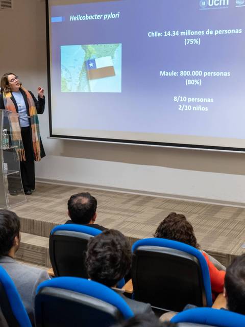 Una presentadora expone sobre estadísticas de personas en Chile en una sala con público atento.