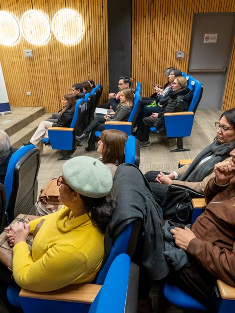 Un grupo de personas sentadas en un auditorio durante un evento.