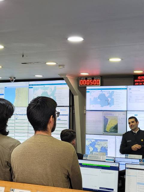 Un grupo de personas escucha atentamente en un centro de comando tecnológico.