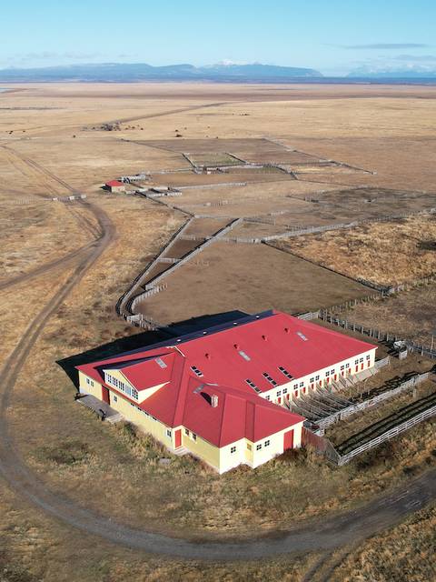 Una vista aérea de un campo amplio con una construcción roja en el centro.
