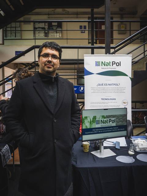 Un hombre posando junto a un stand que presenta tecnologías de Nat Pol.